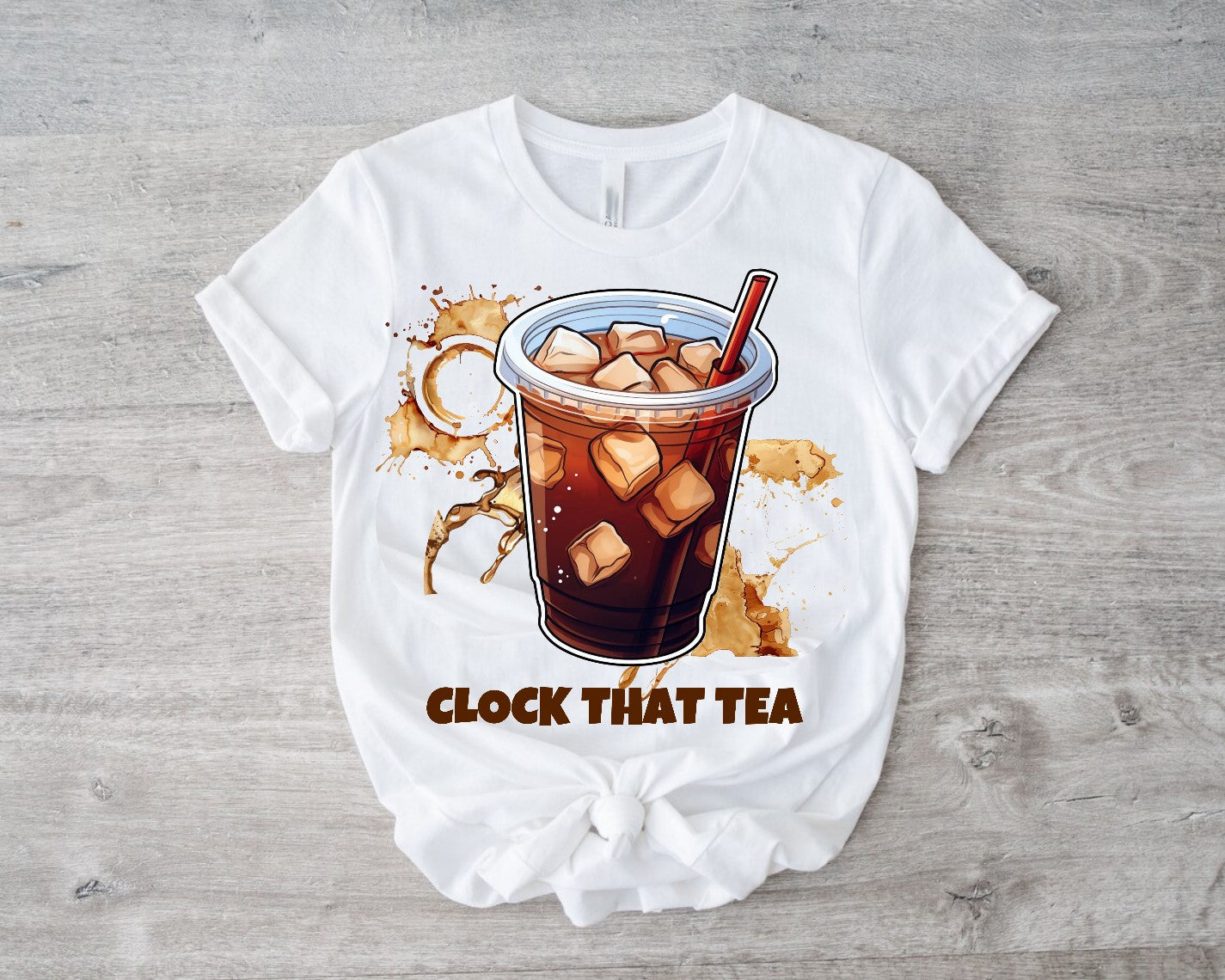 White t-shirt with iced tea graphic and 'Clock That Tea' text on a wooden surface